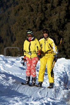 Yong family skiers in yellow rise on ski lift