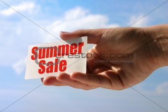 female hand holding sale card