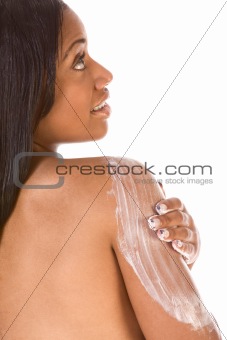 Beautiful black girl applies moisturizer on back