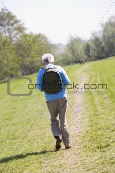 Man walking outdoors with people in background