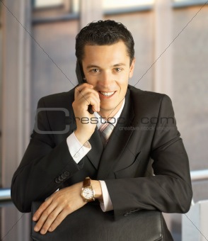 Businessman outside a modern building with cellphone.