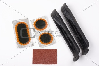 bicycle repair patches and tools on white background