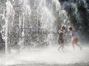 Boys playing in sprinkling water