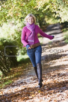 Woman running along autumn path