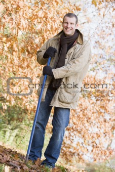 Man tidying autumn leaves