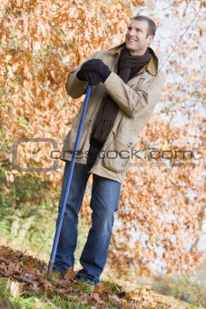 Man tidying leaves in garden