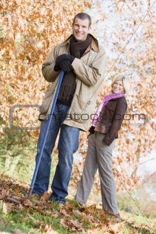 Couple clearing autumn leaves