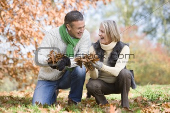 Senior couple collecting autumn leaves