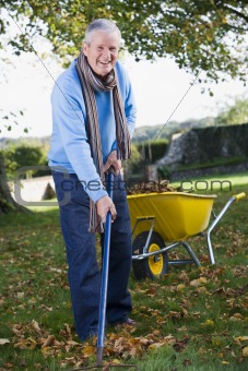 Senior man collecting leaves