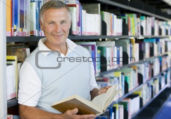 Senior man reading in a library