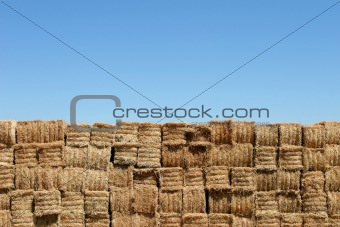 hay bales wall against blue sky