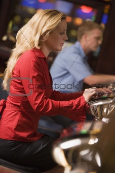 Woman sitting at slot machine in casino