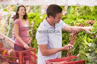 Couple flirting in supermarket aisle