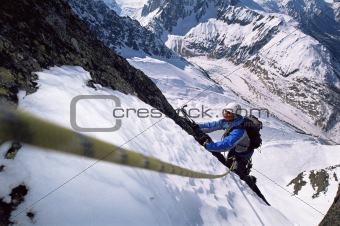 Young men mountain climbing on snowy peak