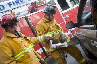 Firefighters cutting open a car to help an injured person