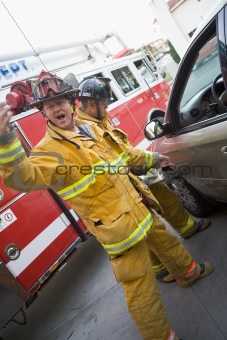 Firefighters cutting open a car to help an injured person