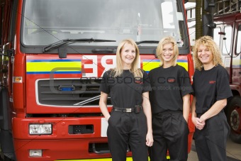 Portrait of firefighters standing by a fire engine