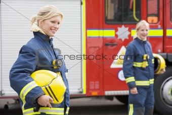 Two female firefighters by a fire engine