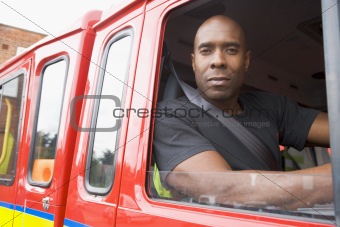 Male firefighter sitting in the cab of a fire engine