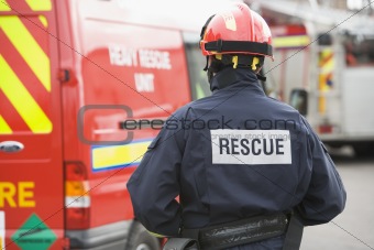 A firefighter standing by a small fire engine