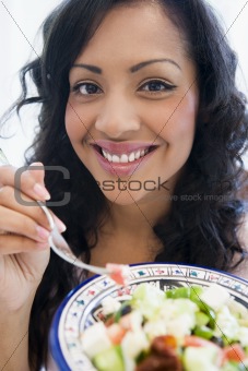 A South American holding a salad up to the camera