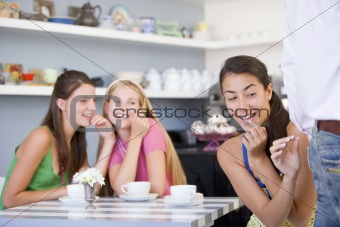 Young woman in a cafe preparing to pinch waiters bottom