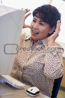 Mature female student expressing frustration at computer