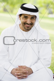 A Middle Eastern man sitting in a park