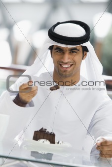 A Middle Eastern man enjoying a meal in a restaurant