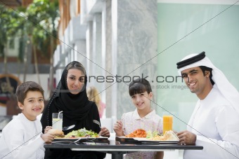 A Middle Eastern family enjoying a meal in a restaurant