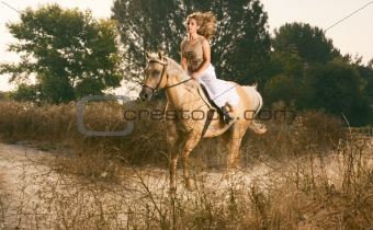 Young woman racing on horse (motion blur)