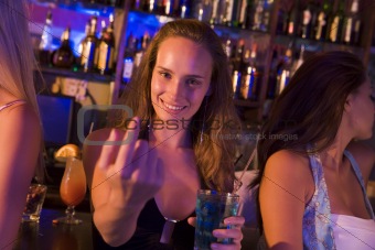 Young woman in nightclub beckoning to camera
