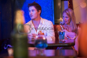 Young woman looking at a young man in a nightclub