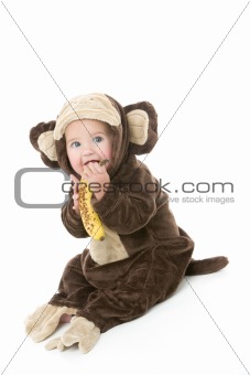 Baby in monkey costume holding banana