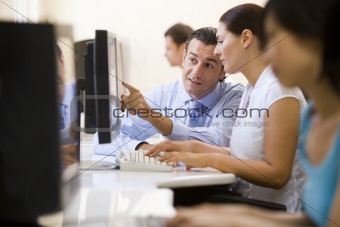 Man assisting woman in computer room