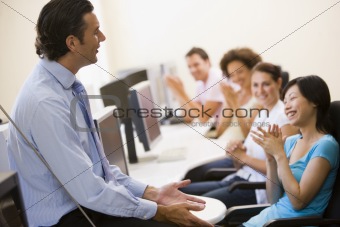 Man giving lecture in applauding computer class