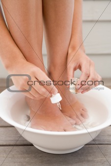 Woman giving herself pedicure