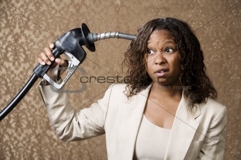 Woman Holding Gas Nozzle to her Head