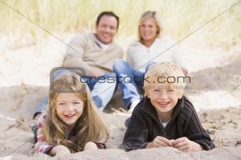 Family relaxing on beach smiling