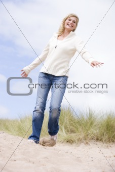 Woman walking on beach smiling