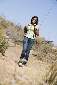 Woman walking on beach path smiling