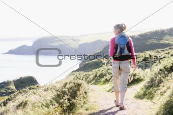 Woman walking on cliffside path
