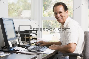 Man in home office at computer smiling