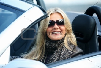 Blond smiling woman in a car