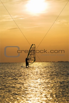 Silhouette of a windsurfer on a sunset