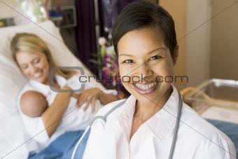 Doctor Standing In Her Patients Room,Woman Holding Baby