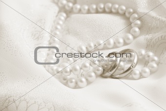 Wedding background: pearls and wedding bangs on a fabric.Toning in sepia.