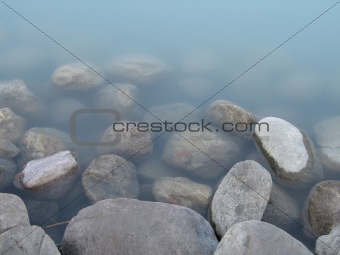 grey polished rocks and green river water