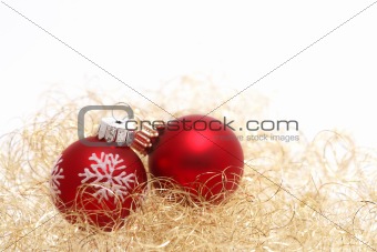 Two red christmas balls in golden wool