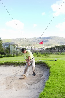 Golfer playing out of a sand trap